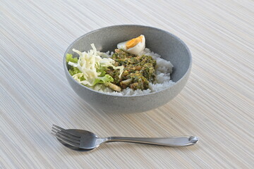 green chili squid rice with salad on wooden table (natural light)