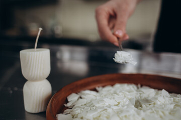 Close up of white soy wax flakes for candle making in a ceramic bowl.