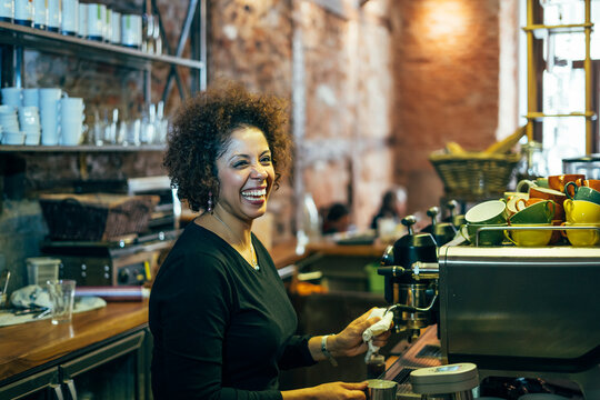male waitress barista working in coffee shop. Prepare decorated coffee
