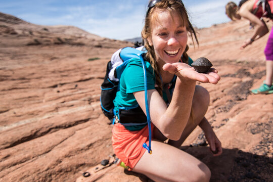 Woman holding Moqui Marble, Grand Staircase-Escalante National Monument, Utah, USA