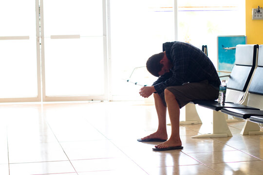 An exhausted male traveler waits in an airport terminal for his flight to arrive at the Manzanillo International Airport in Colima, Mexico.
