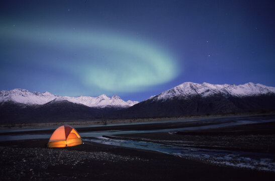 The aurora borealis glows above a tent in Alaska's Knik River Valley.