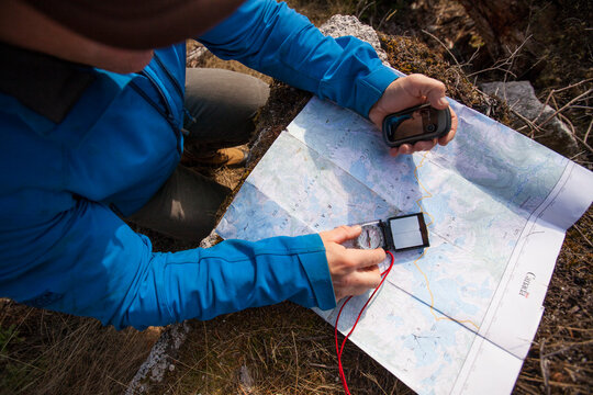 Man using map, compass and&Acirc;&nbsp;GPS&Acirc;&nbsp;to navigate while hiking