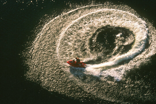 Aerial View of a jet ski cutting a circle in the middle of the lake.