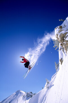 Male skier hucking off of a cliff in Alta, Utah.