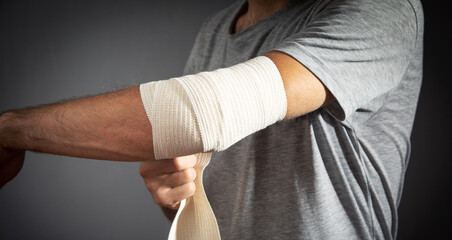 Man bandaging an elbow. First aid and medicine concept