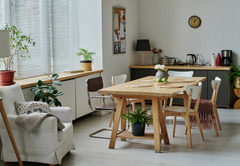 Horizontal image of light apartment with modern design with cozy armchair and dining table in the centre of room