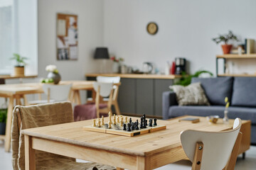 Chess board for playing on wooden table in modern living room