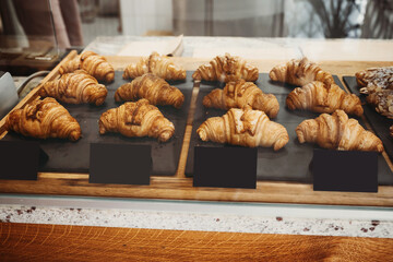 Interior details at the bakery and coffee shop. Bistro showcase with shelves of freshly croissants and bread in assortment.