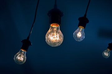 light bulbs on a dark blue background. concept of consumption and energy crisis