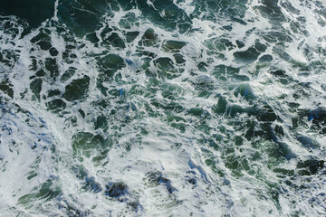 Background. The texture of the ocean. Top view of sea waves, water, sea foam