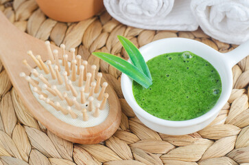 Homemade matcha green tea (kelp, algae, spirulina) face or hair mask (scrub) in a small white bowl...