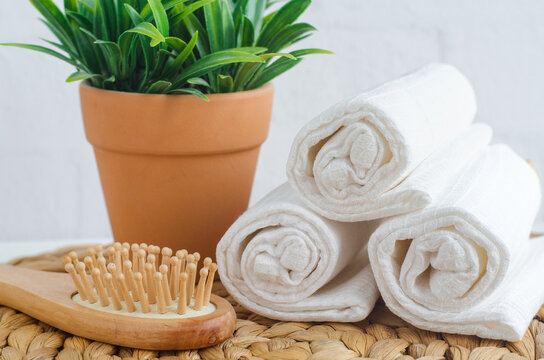Wooden hairbrush and rolled white waffle face cloth. Natural skin care and hair treatment. Eco friendly accesories, zaro waste concept.