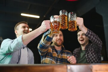 Group of excited friends in beer pub watching sports match