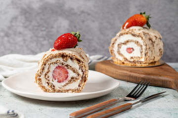 Strawberry Roll Cake. Log cake with cream and strawberries on a stone background. close up