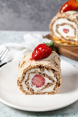 Strawberry Roll Cake. Log cake with cream and strawberries on a stone background. close up