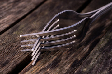 Two forks entwined on a rustic wooden table