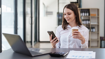 Smiling asian business woman with smartphone in office. Woman in casual at office