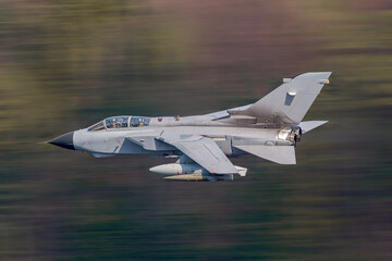 Fighter Jet flying low level in the united kingdom. Lake District, Wales and Scotland, UK low level pilot training - obrazy, fototapety, plakaty