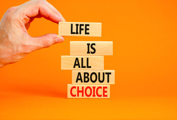 Choice and life symbol. Concept words Life is all about choice on wooden blocks. Beautiful orange table orange background. Businessman hand. Business choice and life concept. Copy space.