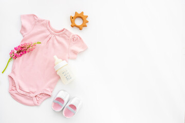 Baby cotton bodysuit with bottle of milk and toys