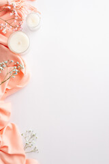 Hello spring concept. Top view vertical photo of pink soft plaid candles in glass holders and gypsophila flowers on isolated white background with copyspace