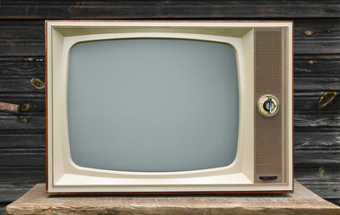 Old vintage TV on the background of a wooden wall.