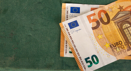 Closeup of fifty euro currency note on green table with copy space