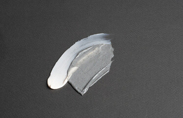 Smear of creamy cosmetic and product with granules