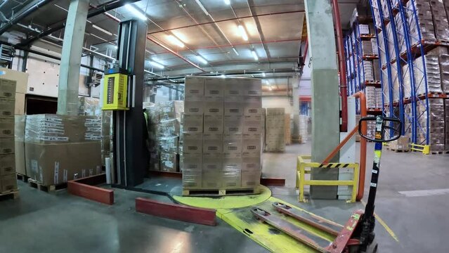 Packing boxes in plastic film timelapse. Box stretch wrapping machine. pallet wrapping machine. Machine for wrapping boxes in a plastic film in a circle.