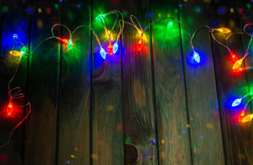 Colourful Christmas lights on green table top with copy space