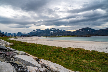Photograph of Rambergstranda beach in Lofoten, Norway, during spring on a clear day with clouds
