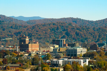 Aerial view of Asheville city in North Carolina with high buildings and mountain hills in distance