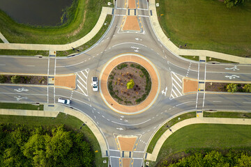 Aerial view of road roundabout intersection with moving cars traffic. Rural circular transportation...