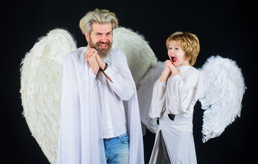 Valentines day. Son and dad in angelic wings. Little cupid boy and father in white clothes.