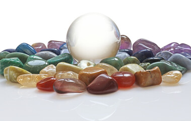 large clear crystal scrying ball with a selection of chakra colored healing crystals  transparent png file