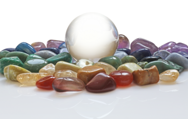 large clear crystal scrying ball with a selection of chakra colored healing crystals  transparent png file