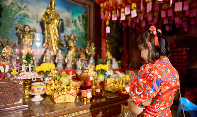 thai woman praying at temple in yaowarat china town bangkok during chinese new year wearing cheongsam