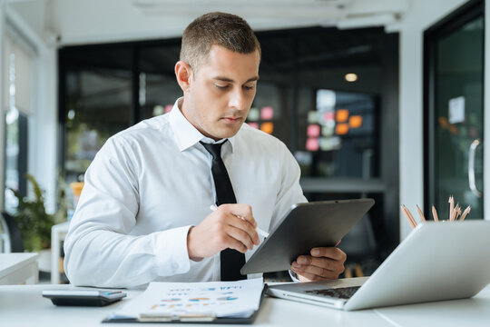 Male businessman using a tablet and computer to analysis graph company financial in office.