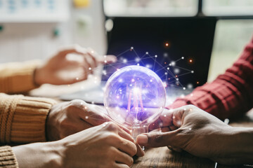 Team hand holding a light bulb. Concept, idea with innovation and teamwork inspiration.