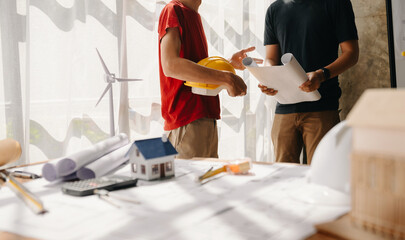 Fototapeta premium Creative architect projecting on the big drawings in the dark loft office or cafe in morning light..