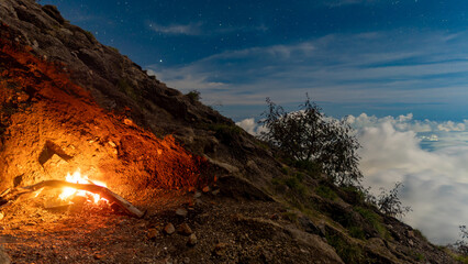 Night at the top of the Agung volcano. Panoramic view of East Java and Bali against the background of clouds. The background of the natural landscape. Bali Island, Indonesia © Sergei Kuldiaev