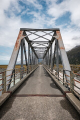 Iron bridge over the Hooker River near Mount Cook in the South Island of New Zealand with mountains in the distance