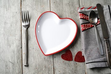 Valentine's day table setting with heart shaped plate fork knife spoon and napkin
