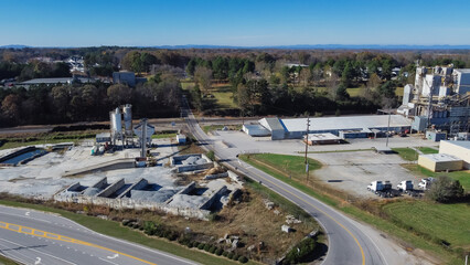 Industrial zone with ready-mixed concrete batching plant, animal feed manufacturer near highway with Chestnut Mountain background in Georgia, USA