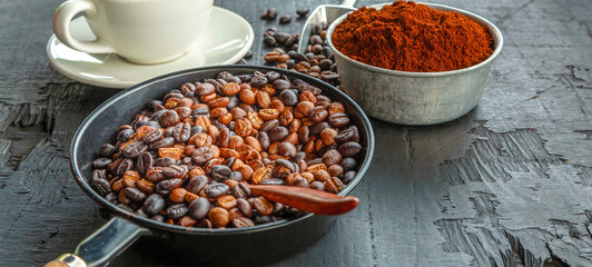 Blended roasted coffee beans or mix coffee beans with ground coffee beans and coffee powder on a black background.