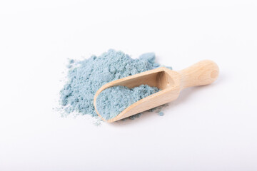 Blue spirulina powder in wooden spoon isolated on white background. Natural vegan superfood. Food supplement. Phycocyanin extract.