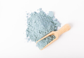 Blue spirulina powder in wooden spoon isolated on white background. Natural vegan superfood. Food supplement. Phycocyanin extract.
