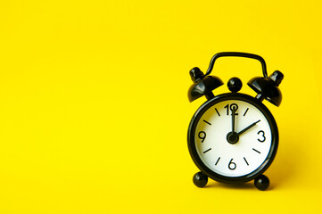 Alarm clock pointing at 2 am or pm with customizable space for text or ideas. Copy space with yellow background