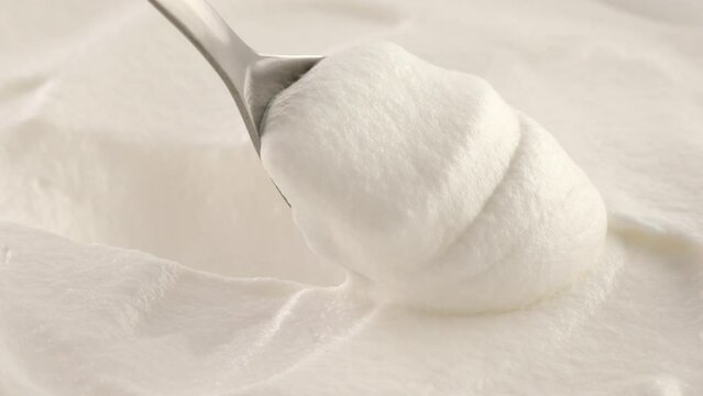 Whipped cream with a spoon. white cream close-up. dessert preparation. pastry kitchen
